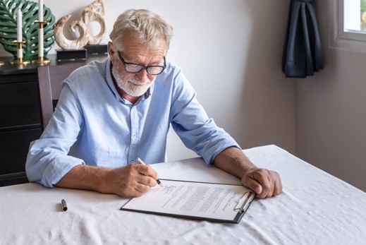 elderly man reviewing and signing will